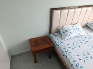a bed with a night stand next to a bed with a pillow at Home stay in varanasi by gaurav in Ahraurā Road