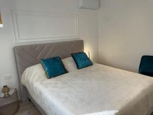 a bed with two blue pillows on top of it at Luxury Villa Olga in Biograd na Moru