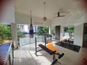 a living room with a gym with tread machines at Delano Residency in Kaliyal