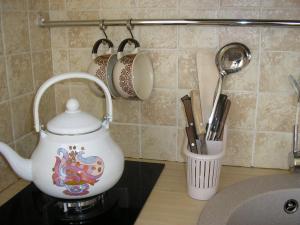 a white tea kettle on a stove with utensils at Žuvėdrų g. 27 in Šventoji +78 photos
