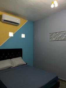 a bedroom with a bed with a blue wall at Discreet luxury in an exclusive area in Matamoros