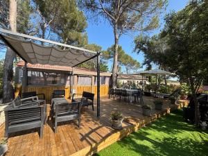 a wooden deck with tables and chairs on it at Le Chalet du Bonheur in Puget-sur Argens