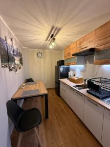 a kitchen with a wooden table and a dining room at Apartament Chowańcówka z widokiem na góry typu studio obok stoków narciarskich i blisko basenów termalnych in Bukowina Tatrzańska