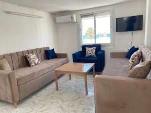 Una sala de estar con dos sofás y una mesa. en Hauvre Marin, en Kelibia