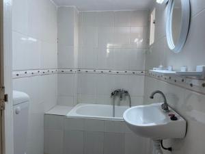 Un baño blanco con lavabo y bañera. en Hauvre Marin, en Kelibia