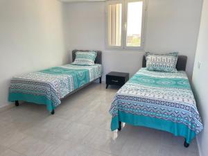 Un dormitorio con dos camas y una ventana. en Hauvre Marin, en Kelibia