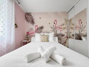 a bedroom with a large white bed with pink flowers at T3 Cosy climatisé à Albi avec Terrasse, & Parking in Albi +32 photos