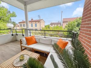 a patio with a couch and a table on a balcony at T3 Cosy climatisé à Albi avec Terrasse, & Parking in Albi