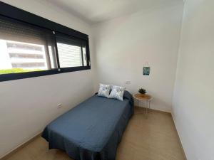 a small bedroom with a bed and a window at Duplex de Zoraida in Roquetas de Mar