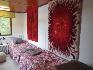 a bedroom with a bed with a red blanket at Mini cottage by lake Saimaa in Enonkoski