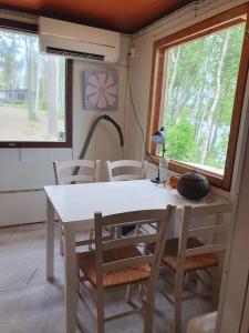 a dining room with a white table and chairs at Mini cottage by lake Saimaa in Enonkoski