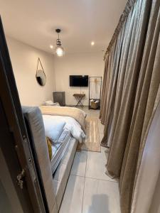 a bedroom with a bed and a tv and curtains at DOMIN LUXURY SUITES in Cape Town