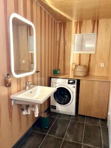 a bathroom with a washing machine and a sink at Fjordview Ryten 2 Retreat in Sund +49 photos