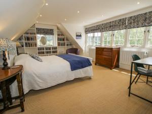 a bedroom with a bed and a desk and chairs at Garden Cottage in Ledbury