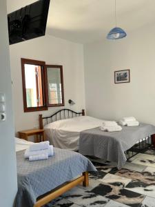 a bedroom with two beds and a flat screen tv at Proavlio in Moutsoúna