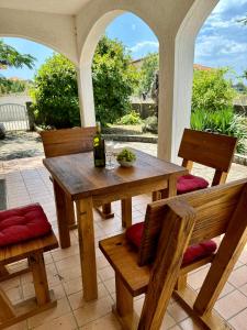 a table and chairs on a patio with a bottle of wine at Villa BiBo in Linardići
