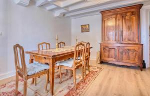 a dining room with a wooden table and chairs at Charmante Maison Avec Piscine in Savignac-les-Églises