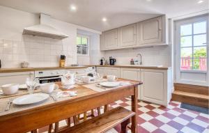 a kitchen with a wooden table with plates on it at Charmante Maison Avec Piscine in Savignac-les-Églises