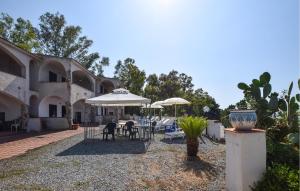 eine Terrasse mit Tischen und Sonnenschirmen vor einem Gebäude in der Unterkunft Pet Friendly Apartment In Parghelia in Parghelia