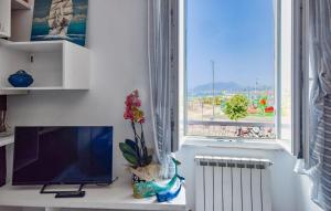 a desk with a flat screen tv and a window at Nice Apartment In Sestri Levante in Sestri Levante +8 photos