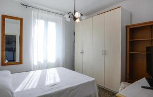 a white bedroom with a bed and a mirror at 2 Bedroom Awesome Apartment In Terrile in Uscio