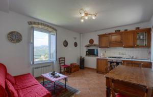 a living room with a red couch and a kitchen at Lovely Apartment In Moneglia With Wifi in Moneglia