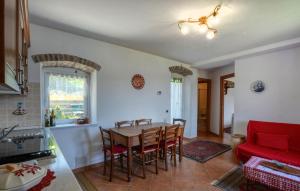 a kitchen and dining room with a table and a red couch at Lovely Apartment In Moneglia With Wifi in Moneglia