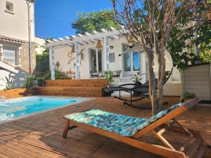 a patio with a chair and a tree next to a pool at Villa Jalna bis in Béziers
