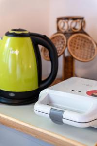 a green and black tea kettle on a table at Cozy Beachfront Cottage with Sea Loungers & Outdoor Shower near Eretria in Eretria
