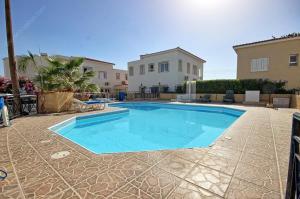 ein Swimmingpool in der Mitte eines Hofes mit einem Haus in der Unterkunft Studio Panthi in Paphos City