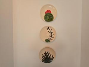 three plates on a wall with plants on them at La Casa de la Cerámica in Níjar +22 photos