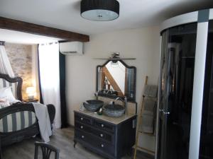 ein Badezimmer mit Waschbecken und Spiegel auf einer Kommode in der Unterkunft Chez Jérôme, au pied de la cité médiévale in Carcassonne