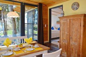 a dining room with a table and chairs and windows at TraumBlick in Rimsting