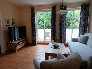 a living room with a couch and a tv at Störtebeker 07 in Kühlungsborn