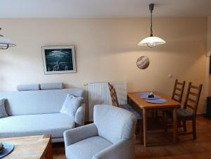 a living room with a couch and a table and chairs at Störtebeker 07 in Kühlungsborn