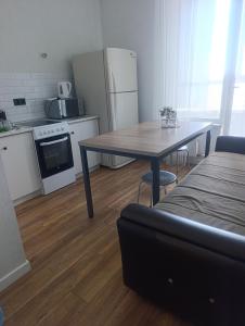 a small kitchen with a table and a refrigerator at Satsiti Блок Н in Astana