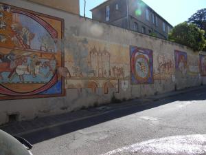 eine Wand mit Gemälden an der Seite einer Straße in der Unterkunft Chez Jérôme, au pied de la cité médiévale in Carcassonne + 3 Fotos