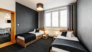 um quarto de hotel com duas camas e uma janela em Penzion Bird's Nest em Brno
