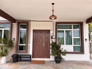a house with a brown door and windows at Duyong Damai Homestay by KOWBMAS in Melaka