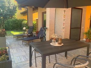 Un patio con una mesa y sillas y una sombrilla. en Villa Rosa, en Givoletto 106 fotos más