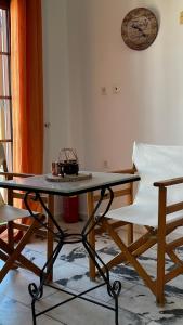 a table and chairs in a room with a clock on the wall at Proavlio in Moutsoúna +29 photos