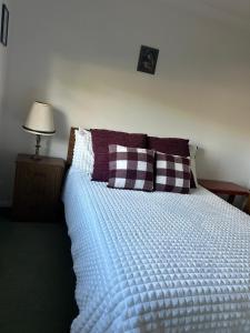 Un dormitorio con una cama con una manta azul y almohadas. en Orchid House Shared, en Stanthorpe