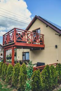 a house with a deck on the side of it at Beskidzki Zakątek in Żabnica