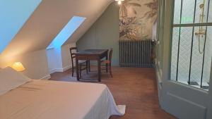 a bedroom with a table and a bed and a table and chairs at La Maison du Griffoul BB à Salles la Source cascade et terroir in Salles-la-Source