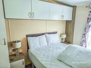 a bedroom with a bed with white sheets and white cabinets at Sea views at Serenity! in Truro