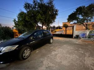 un coche negro aparcado en un estacionamiento en Ajla Apartment, en Ksamil
