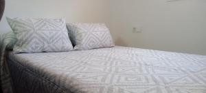 a bed with two pillows on top of it at La posada del Mozarabe in Alquife