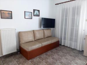 a couch sitting in a living room with a flat screen tv at Kalliopi's Aegean View in Episkopíon