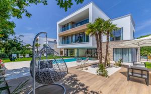 a large white house with a pool and palm trees at Brand New Design Villa with Heated Pool and Sea view in Pomer