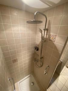 une salle de bain avec une douche avec pommeau de douche dans l'établissement Longère 7 personnes - 4 chambres - 3 SdB Orcival, à Vernines
